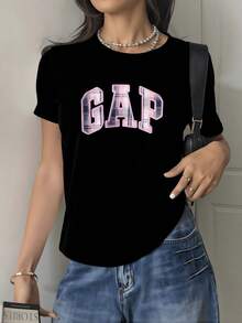 Letras grandes en tono rosa con efecto de textura representan energía juvenil y actitud moderna creando un contraste elegante sobre fondo oscuro ideal para un look casual camiseta de mujer cómoda y versátil para uso diario - Negro - Ver 1