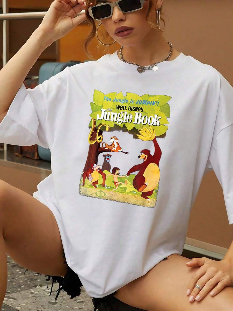 El estampado muestra una alegre escena en la selva donde animales y un niño bailan bajo hojas verdes transmitiendo libertad y amistad camisetamujer casual cómoda para uso diario y look relajado - Blanco - Ver 1