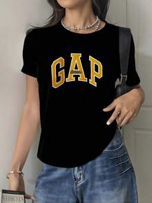 Letras grandes en tono dorado con contorno claro que expresan energía juvenil y confianza moderna en estilo urbano casual camiseta de mujer cómoda para diario - Negro - Ver 8