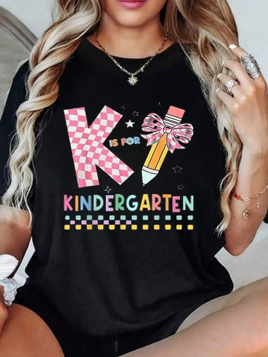 Letra K en patrón rosa con lápiz adornado con lazo simboliza creatividad y aprendizaje temprano en colores vivos ideal para maestras o madres orgullosas de sus pequeños 100% algodón camiseta para mujer