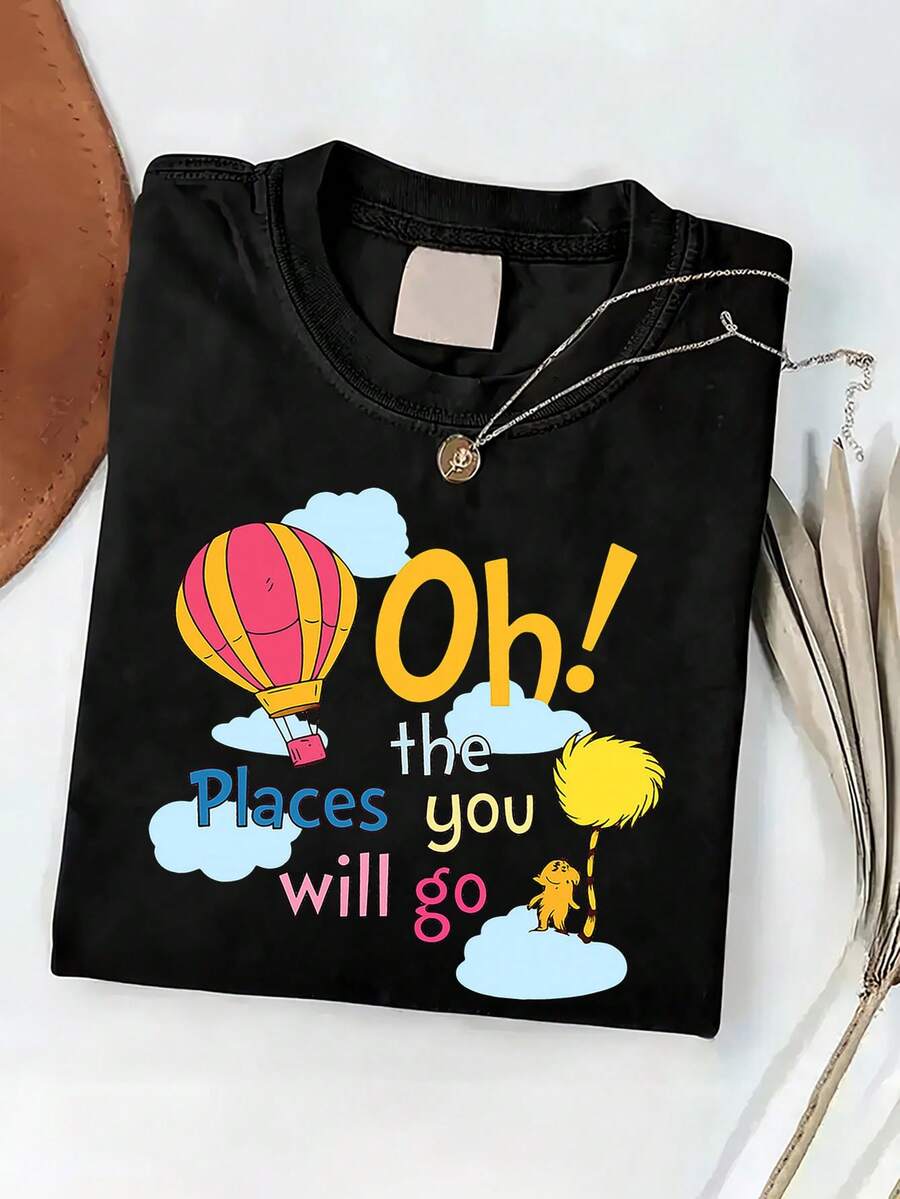 Camiseta morada relajada con cuello redondo y mangas cortas que presenta la frase 'Oh!' Los Lugares a los que Irás con un Diseño de Globo Aerostático. Es ideal para usar en casa, para salidas o como regalo. 100% algodón. - Negro - Ver 1