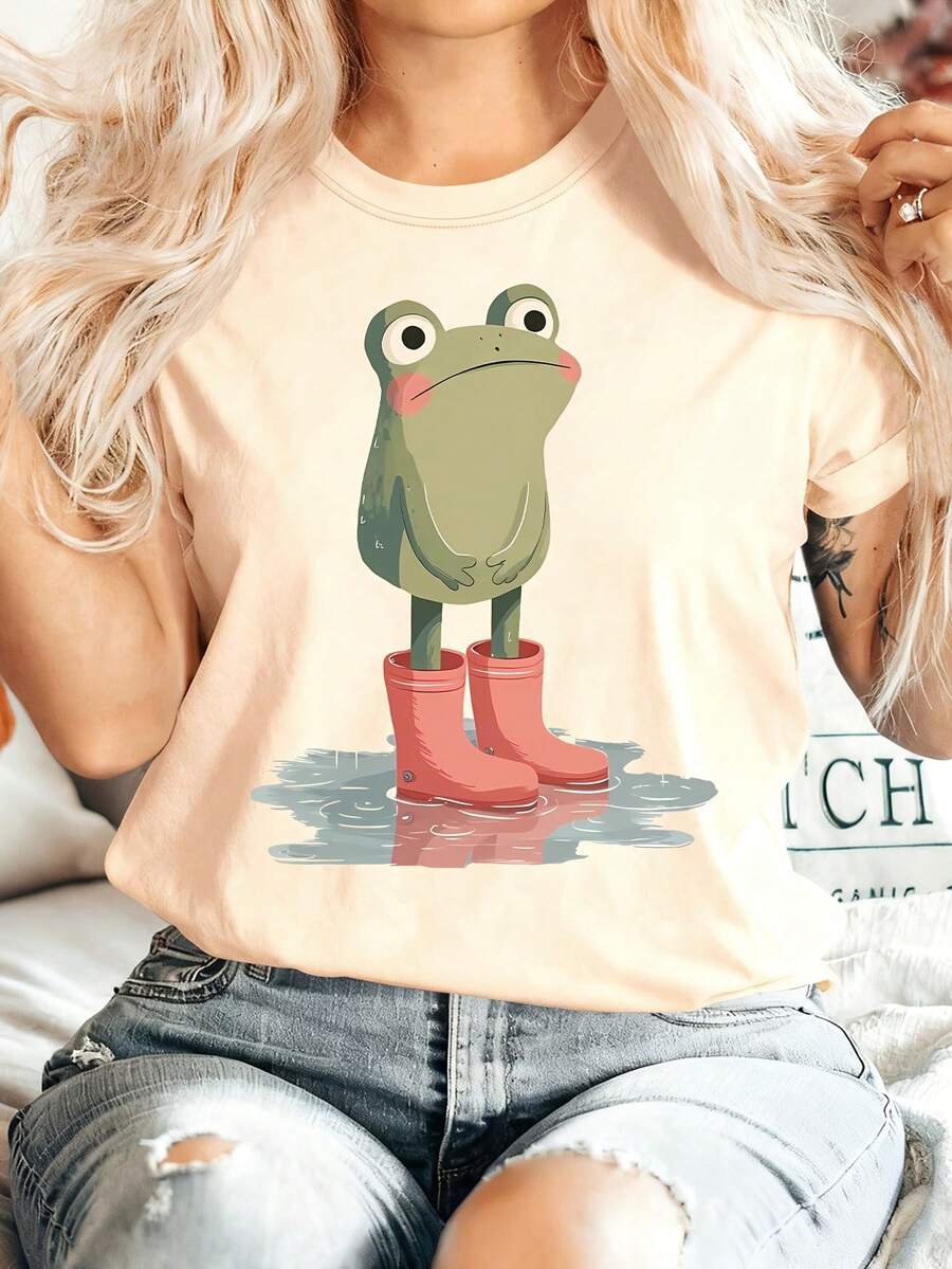 [Summer Energy] Women's Summer Clothing: A Short-Sleeved, Crew-Neck T-Shirt Featuring A Small Frog Standing In A Puddle Wearing Pink Rain Boots. Comfortable, Soft, Stylish, Suitable For Parties, Vintage Style, Casual Wear, And Versatile. Suitable For Spring, Summer, Autumn, And Winter, This Sporty Top Is Made Of 100% Cotton. - 杏色 - 查看 1