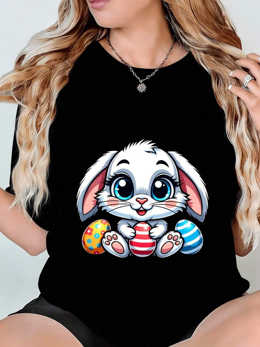 Camiseta de mujer, estampada con un conejo de Pascua sosteniendo un huevo colorido sobre un fondo negro, lavable a máquina, unisex, transpirable y cómoda, un excelente regalo para aniversarios y días festivos. Camisetas gráficas de verano para mujer, camiseta casual estampada de manga corta y cuello redondo, moda urbana local de primavera/verano. - Negro - Ver 1