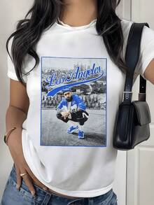 Vista urbana de Los Ángeles con tipografía retro en tonos azules y fondo panorámico de ciudad que transmite energía moderna y confianza camiseta de mujer casual moderna para uso diario - Blanco - Ver 1