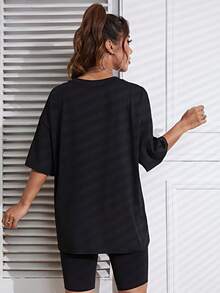 Camiseta de cuello redondo y hombros caídos con estampado gráfico bidimensional de una chica con diseño de círculos. - Negro - Ver 2