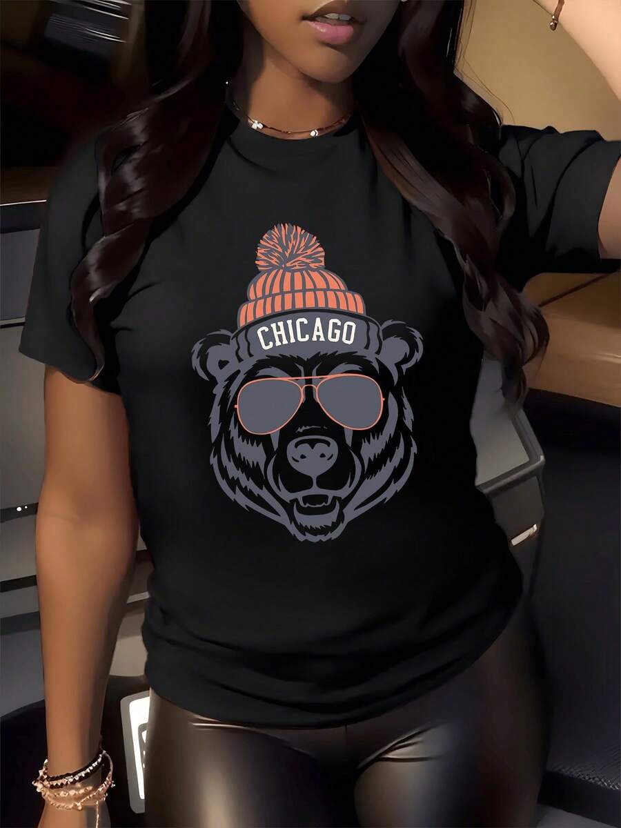A Bear Wearing An Orange Knitted Hat And Sunglasses, Along With The Name Chicago, Symbolizes Strength, Confidence, And Urban Energy, Reflecting The City's Adventurous And Modern Spirit. This Comfortable And Attractive Women's Casual T-Shirt Is Perfect For Women. - 黑色 - 查看 1