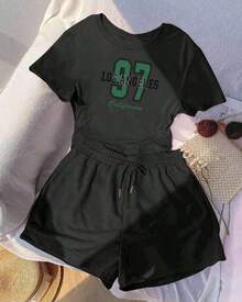 Almacén local, una camiseta de manga corta para mujer con estilo retro americano, de corte holgado y diseño estampado (los pantalones son solo para sugerencias de estilo). Esta pieza sencilla y elegante presenta un patrón de letras impresas con temática tropical, lo que la convierte en un elemento imprescindible para crear un look relajado de vacaciones, perfecto para ocasiones como el Día del Trabajo y el Día de la Independencia de México. - Negro - Ver 1