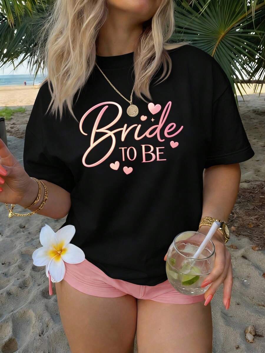 Elegante camiseta de manga corta con cuello redondo para mujer, hecha de fibra, lavable a máquina y fácil de cuidar, con estampados de letras casuales y un diseño de corazón rosa con la frase "Bride to Be", una nueva camiseta de verano 2026, adecuada para viajes y uso diario, camiseta de moda chic. - Negro - Ver 1