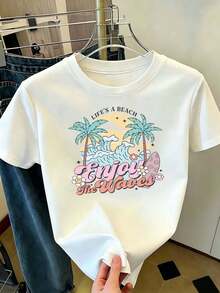 Camiseta para Mujer Blanca con Estampado Tropical de Palmeras, Olas y Tabla de Surf, Frase "Life's a Beach Enjoy the Waves", Cuello Redondo de Manga Corta, Top Casual de Playa, Ropa Cómoda para Verano y Vacaciones, Ajuste Regular para Salidas Informales - Blanco - Ver 1