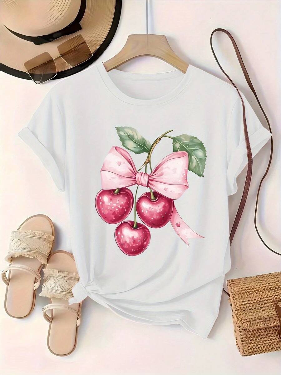 Nueva camiseta de mujer para todas las estaciones, con cuello redondo y mangas cortas, decorada con tres cerezas rosas, un lazo en forma de corazón rosa y hojas verdes. Los colores son dulces y suaves, y el estilo es lindo y delicado, con un diseño estampado romántico y dulce. - Blanco - Ver 1