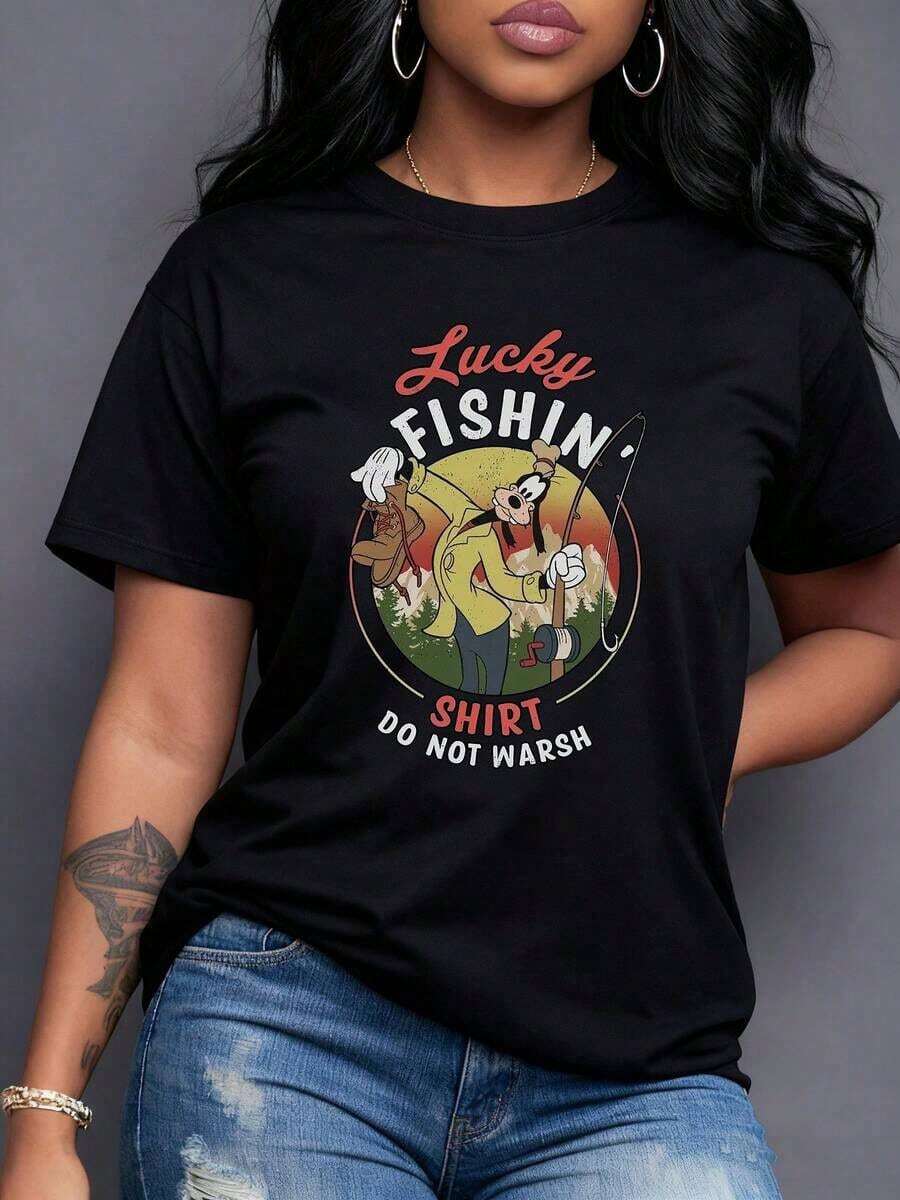 Suerte y pesca afortunada con personaje caricaturesco sosteniendo caña frente a paisaje colorido que transmite diversión relajada y aventura camiseta para mujer con toque urbano y alegre,Camiseta de mujer elegante. - Negro - Ver 1
