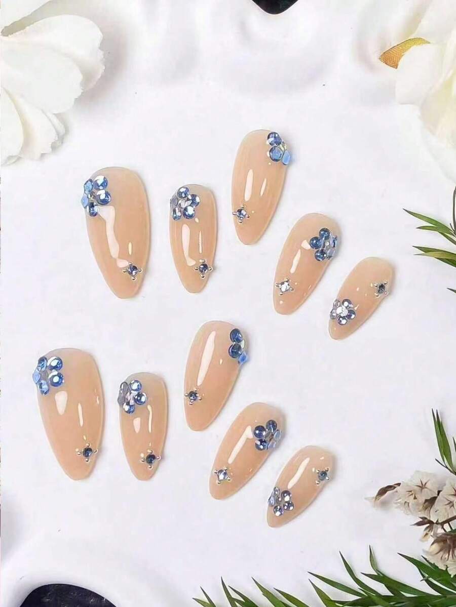 10片手工杏仁形美甲贴片,裸色底色,饰以蓝色水钻小花。美甲采用柔和的裸色底色,点缀着精致的蓝色水钻花朵和银色小钢珠。优雅、浪漫、简约,尽显高端、性感、奢华质感。 - 彩色 - 查看 1