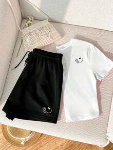 Una camiseta de manga corta para mujer con estilo retro americano, de diseño holgado y estampado (los pantalones son solo sugerencias de estilo). Este artículo sencillo y elegante presenta patrones de texto con temática tropical, siendo un elemento imprescindible para crear un estilo relajado de vacaciones. Es muy adecuado para ocasiones como el Día del Trabajo y el Día de la Independencia de México. La gruesa camiseta multicolor está hecha de 100% algodón con estampados modernos, y es adecuada tanto para hombres como para mujeres. Es un estilo completamente nuevo para primavera/verano/otoño, transpirable y cómodo, sencillo y versátil. - Blanco - Ver 2