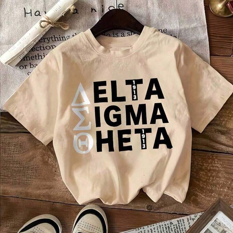 NUEVA Camiseta Negra Delta Sigma Theta 1913 con Texto y Símbolos - Modelo con Cabello Rubio Largo y Ondulado, Collar de Cadena Delgada, Fondo de Tela Clara, Camiseta Casual de Algodón con Cuello Redondo - 100% Algodón, Camisetas Gráficas Vintage Negras para Hombre, Tops Casuales de Primavera Verano, Camiseta Casual de Manga Corta con Estampado y Cuello Redondo para Mujer, Verano| Pascua y Día de San Patricio, Día de la Independencia - Albaricoque - Ver 1