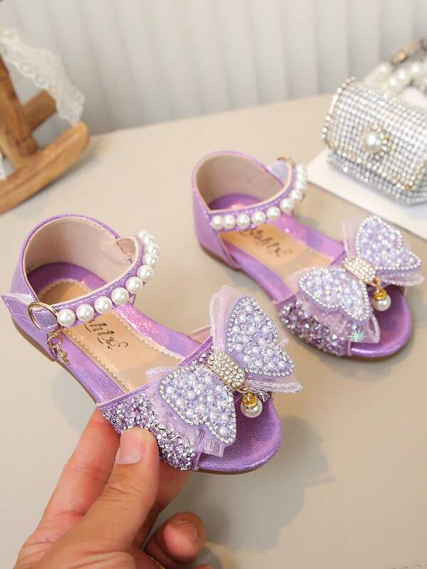Sandal đế bằng kiểu công chúa cho bé gái, trang trí bằng ngọc trai, nơ và đá lấp lánh, đa năng cho sinh hoạt hàng ngày, đi học, dự tiệc, đi biển, nghỉ lễ.