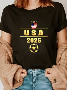 Shield With United States Flag And Golden Ball Symbolizing Passion For Soccer And Unity Towards The 2026 Tournament. Women's Casual, Modern, Comfortable T-Shirt Ideal For Sports Fans. - 黑色 - 查看 1