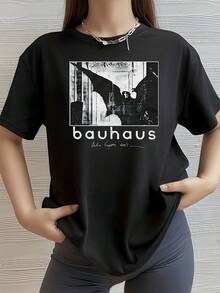 An Artistic Figure Representing A Winged Silhouette Extending Its Arms Against An Architectural Background, Evoking Mystery And Visual Contrast With Modern Typography. A Comfortable, Casual Urban Women's T-Shirt For Everyday Wear. - 黑色 - 查看 1
