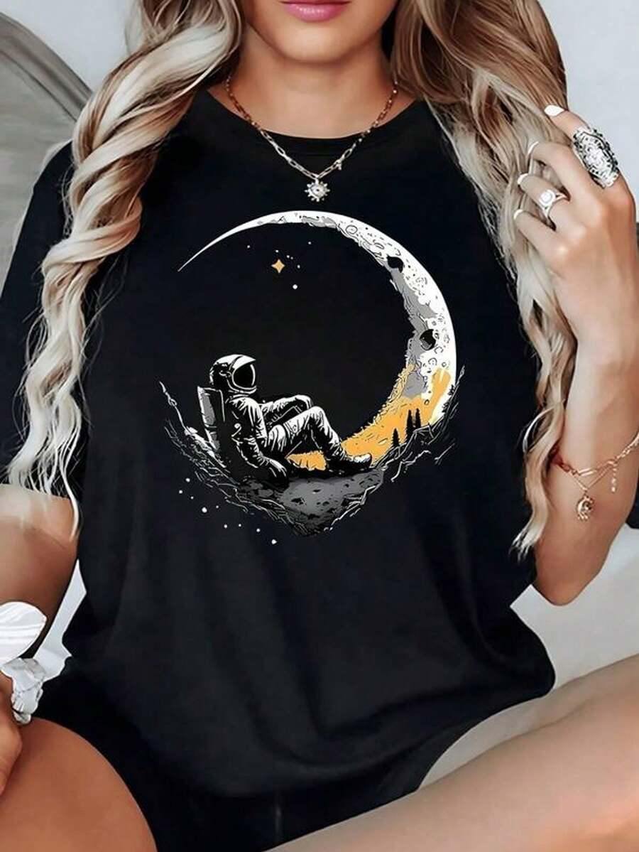Astronauta sentado sobre media luna iluminada contemplando estrellas doradas en un cielo profundo camiseta de mujer 100% algodón 220g