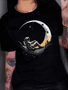 Astronauta contemplando la luna dorada simbolizando los sueños y la libertad en el universo 100% algodón camiseta de mujer moderna y cómoda para uso diario - Negro - Ver 6