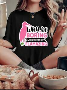 Una camiseta de colores vivos con un flamenco rosa en el lado izquierdo, al lado del cual está escrito el texto BE BORING en letras rosas y blancas. El texto WHEN YOU CAN BE (en blanco) está escrito debajo. -Camiseta unisex de algodón holgada de manga corta y cuello redondo de estilo vintage urbano. - Negro - Ver 1