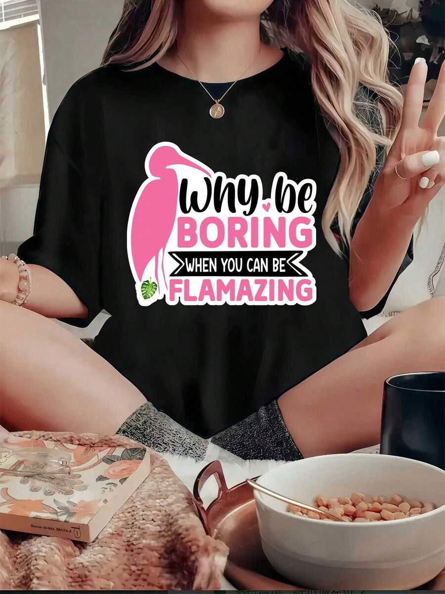 Una camiseta de colores vivos con un flamenco rosa en el lado izquierdo, al lado del cual está escrito el texto BE BORING en letras rosas y blancas. El texto WHEN YOU CAN BE (en blanco) está escrito debajo. -Camiseta unisex de algodón holgada de manga corta y cuello redondo de estilo vintage urbano. - Negro - Ver 1