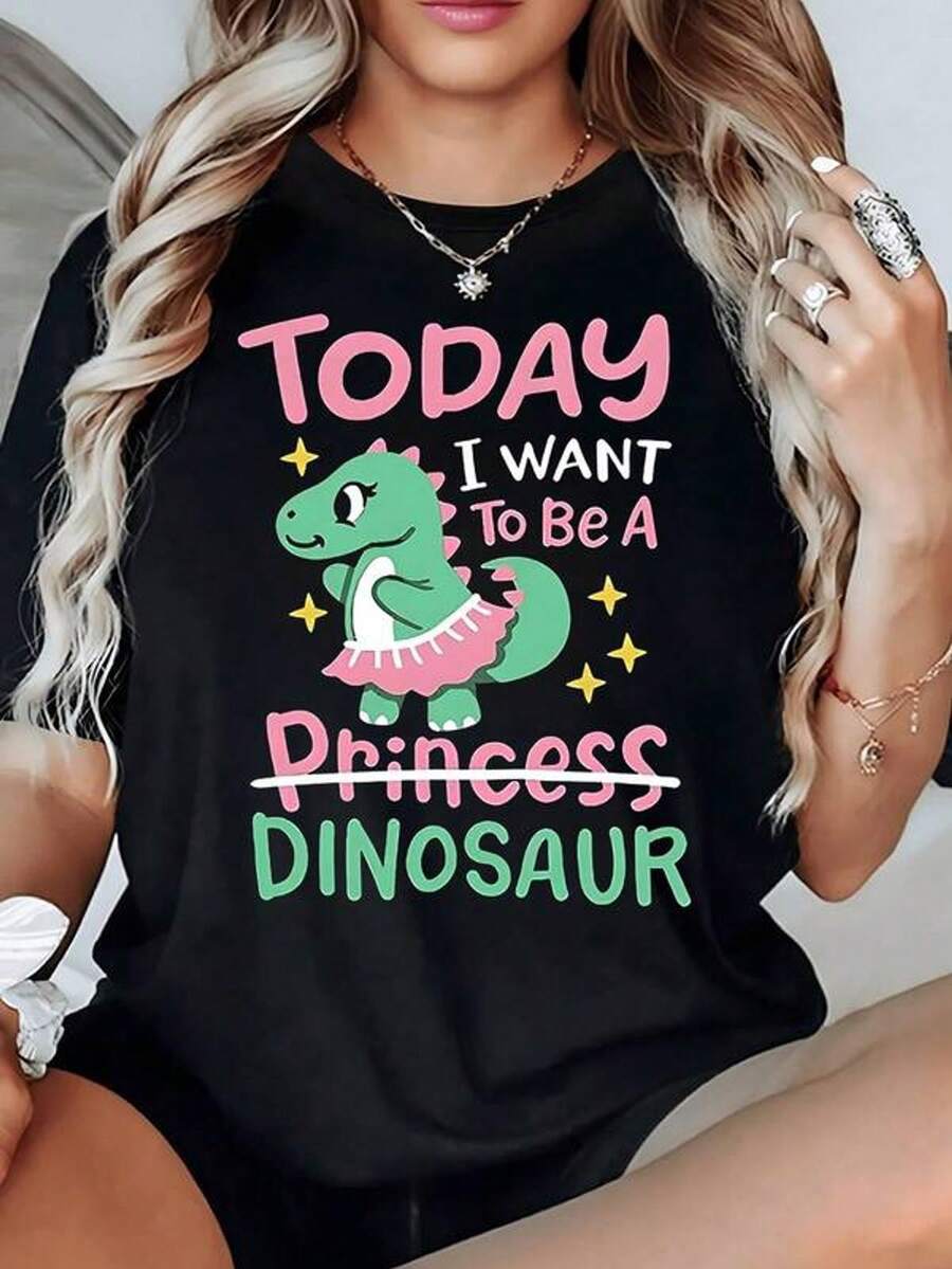 Dibujo de un dinosaurio verde con falda rosa que expresa energía divertida y deseo de ser fuerte y única mostrando empoderamiento femenino en tono alegre camiseta para mujer 100% algodón