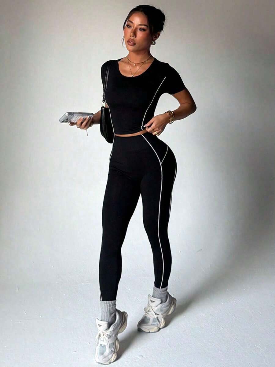 Conjunto deportivo de mujer de ajuste delgado en color negro, con top de manga corta y mallas - Blanco y Negro - Ver 1