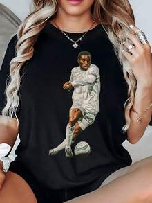 The Image Of A Focused Player Kicking A Ball With Force Symbolizes The Passion And Energy Of The Sport And Conveys Movement And Determination. A Modern, Comfortable, Casual Women's T-Shirt For Everyday Wear. - 黑色 - 查看 1