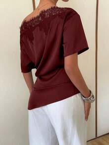 Elegante blusa de satén negro con escote asimétrico en el hombro y ribete de encaje.Esta camiseta de manga corta y bajo asimétrico presenta una silueta estilizadora y favorecedora, convirtiéndola en una opción elegante y versátil tanto para el - Burdeos - Ver 2