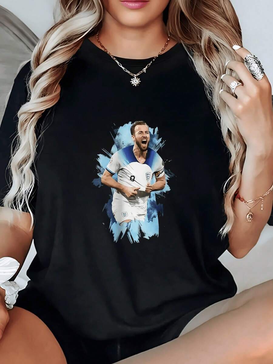 Vibrant Image Of A Football Player Running Energetically Against A Blue Background, Symbolizing Passion, Strength, And Modern Movement. Ideal For Women Who Love Sports And Comfort. Attractive Casual Women's T-Shirt For Everyday Wear. - 黑色 - 查看 1