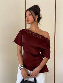Elegante blusa de satén negro con escote asimétrico en el hombro y ribete de encaje.Esta camiseta de manga corta y bajo asimétrico presenta una silueta estilizadora y favorecedora, convirtiéndola en una opción elegante y versátil tanto para el - Burdeos - Ver 6