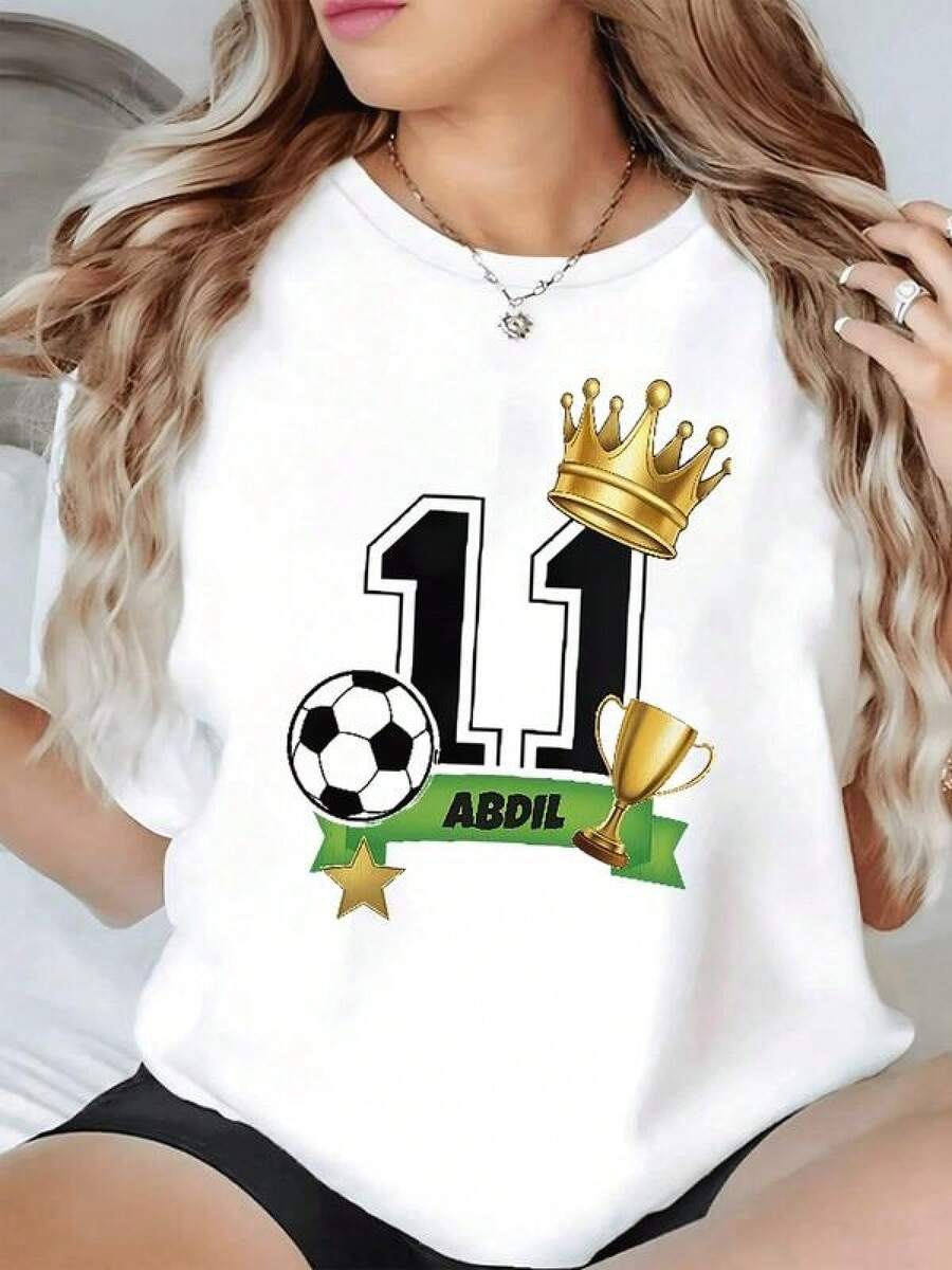 Corona dorada sobre número once acompañada de trofeo balón estrella y cinta verde que simboliza victoria perseverancia y espíritu de campeona camiseta de mujer casual moderna cómoda para verano - Negro - Ver 1