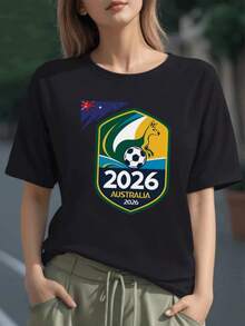 Canguro dorado sosteniendo un balón sobre fondo azul y verde simbolizando energía y espíritu deportivo hacia el futuro de Australia 2026 camiseta para mujer 100% algodón - Negro - Ver 1
