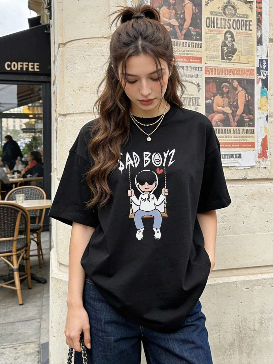 Camiseta de manga corta con cuello redondo suave y casual para mujer, estampado gráfico de dibujos animados de AD BOYZ Swinging Boy, ideal para uso diario.Color negro. - Negro - Ver 1
