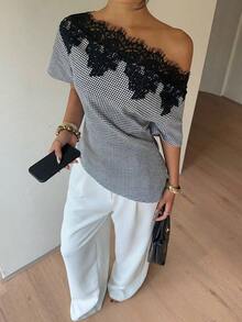 Elegante blusa de satén negro con escote asimétrico en el hombro y ribete de encaje.Esta camiseta de manga corta y bajo asimétrico presenta una silueta estilizadora y favorecedora, convirtiéndola en una opción elegante y versátil tanto para el - Blanco y Negro - Ver 1