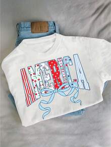 (Ropa de maternidad para mujeres) Camiseta patriótica para el Cuarto de Julio para mujer - Letras "MERCI" en rojo, blanco y azul con la bandera estadounidense, lazos y estrellas - Top de manga corta con cuello redondo, adecuada para ropa del Cuarto de Julio y celebraciones del Día de la Independencia. - Blanco - Ver 1
