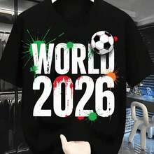 2026 World Cup Football Shirt, Bold White Text With Red Paint - 2026 Splatters And Green Splatters Around The World, Black And White Football Near The 'O', Brown Wristwatch In Hand Holding The Shirt, Casual Crew Neck T-Shirt For Football Fans, Sh Indoor Shop - 黑 - 查看 1