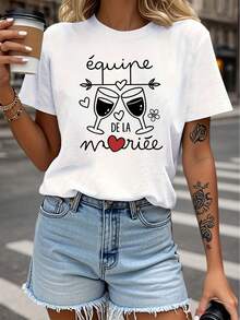 Talla Grande - Talla Grande - Camiseta de Talla Grande con la frase francesa 'Équipe DE LA Mariée' que significa 'El Equipo de la Novia', con diseños de corazones y flores para un tema de fiesta romántica. Esta camiseta blanca de manga corta con cuello redondo y estampado es lavable a máquina. - Negro - Ver 1