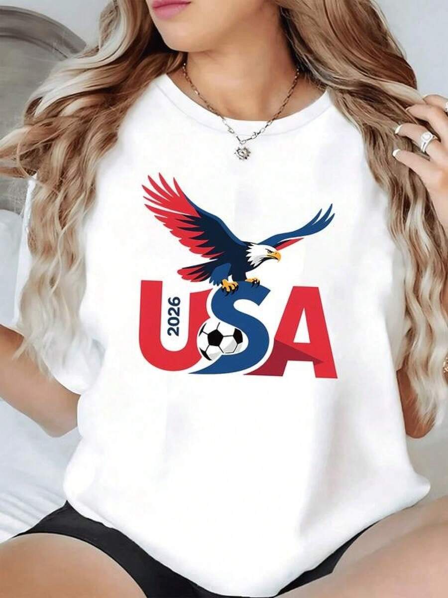 Águila majestuosa de alas extendidas que simboliza fuerza libertad y espíritu competitivo sobre letras grandes USA 2026 con balón deportivo en el centro camiseta de mujer casual moderna cómoda para verano - Negro - Ver 1