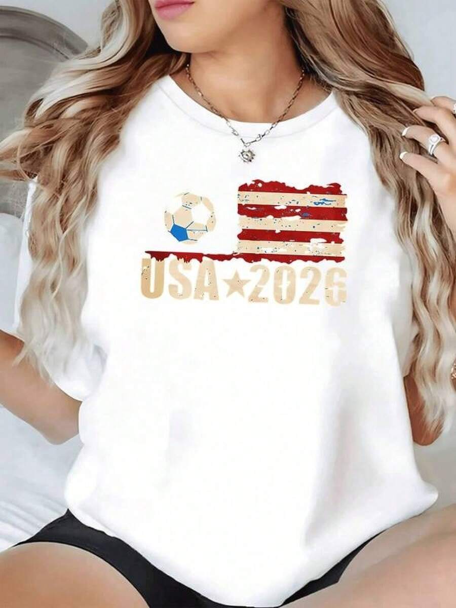 Bandera estadounidense desgastada con balón de fútbol que simboliza la pasión por el deporte y la unión rumbo al torneo mundial 2026 camiseta de mujer casual cómoda para fanáticas del fútbol - Negro - Ver 1