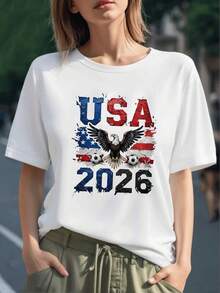 Águila majestuosa con alas extendidas sobre bandera de Estados Unidos y balones de fútbol frente al número 2026 simbolizando fuerza y pasión por el deporte camiseta para mujer 100% algodón - Negro - Ver 1