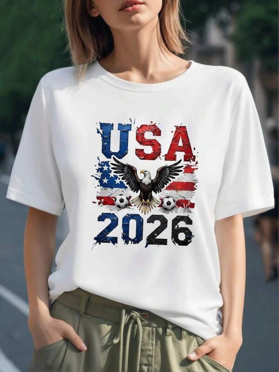 Águila majestuosa con alas extendidas sobre bandera de Estados Unidos y balones de fútbol frente al número 2026 simbolizando fuerza y pasión por el deporte camiseta para mujer 100% algodón - Negro - Ver 1