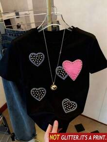 Playera unisex de manga corta y cuello redondoPlayera de manga corta, cuello redondo, con corazón color rosa, con perlas simuladas, estampadas, de corte regular para mujer, para el verano, casual, ideal para uso diario.2026 - Negro - Ver 6