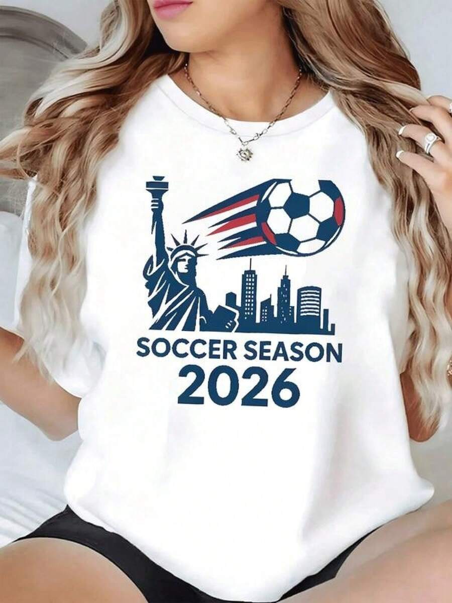 Balón de fútbol en movimiento junto a la Estatua de la Libertad y el horizonte urbano simbolizando la pasión global por el torneo de 2026 camiseta de mujer casual moderna ideal para fanáticas del deporte - Negro - Ver 1