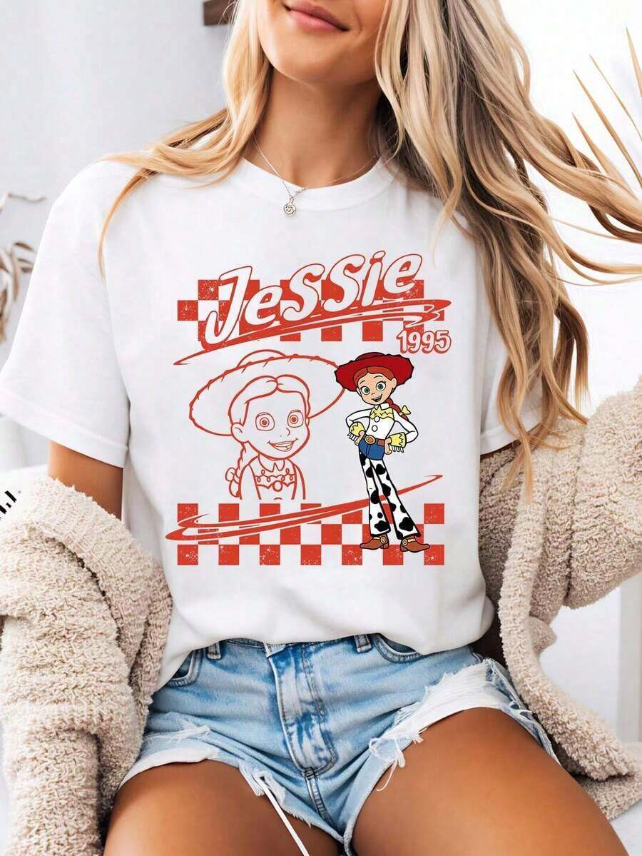Camiseta casual estilo para mujer con estampado de dibujos animados de Jessie de en diseño de tablero de ajedrez de inspiración vintage. Esta camiseta de verano de cuello redondo está confeccionada con un tejido suave y cómodo 100% algodón, perfecta para el uso diario, actividades al aire libre o ir de compras. También es una opción ideal para ropa de vacaciones para mujeres. 100% algodón. Duradero. - Blanco - Ver 1