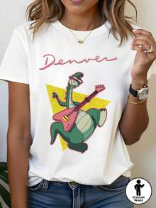 Camiseta Gráfica de Dinosaurio para Mujer Denver Rock - Camiseta Blanca con Dinosaurio Verde, Top Ligero de Cuello Redondo para Conciertos, Festivales y Looks Casuales Diarios - Ropa de Primavera/Verano, Ropa de Festival, Diseño Divertido, Ajuste Cómodo - Blanco - Ver 2
