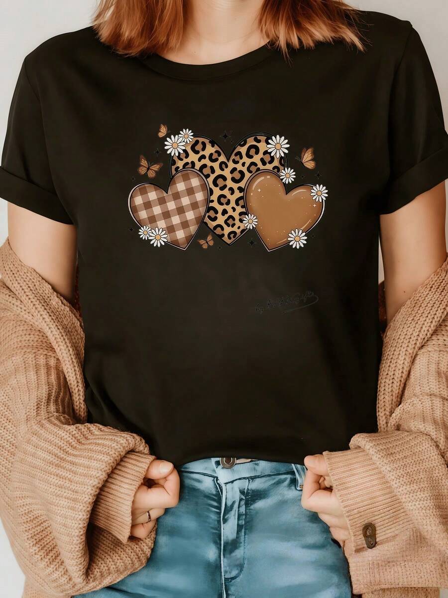 Tres corazones entrelazados muestran amor naturaleza y libertad con estampado de leopardo cuadros y tonos cálidos acompañados de mariposas y flores que evocan ternura y energía positiva camiseta de mujer moderna y casual ideal para cualquier ocasión - Negro - Ver 1