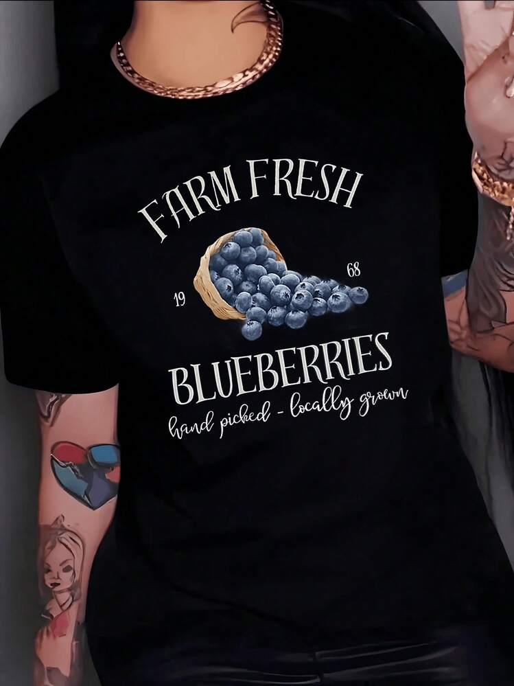 A Basket Full Of Freshly Harvested Blueberries Symbolizes The Freshness Of The Countryside And Traditional Craftsmanship. A Stylish Women's T-Shirt With A Casual Look And A Natural Touch, Ideal For Everyday Wear. - 黑色 - 查看 8