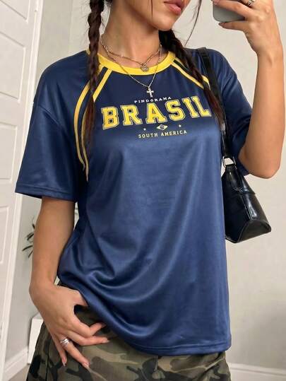 Áo thun thể thao dáng rộng màu xanh hải quân và vàng in chữ "BRASIL", kiểu dáng thường ngày lấy cảm hứng từ áo đấu Brazil thời kỳ Y2K, tay ngắn, thích hợp cho nữ mùa hè.