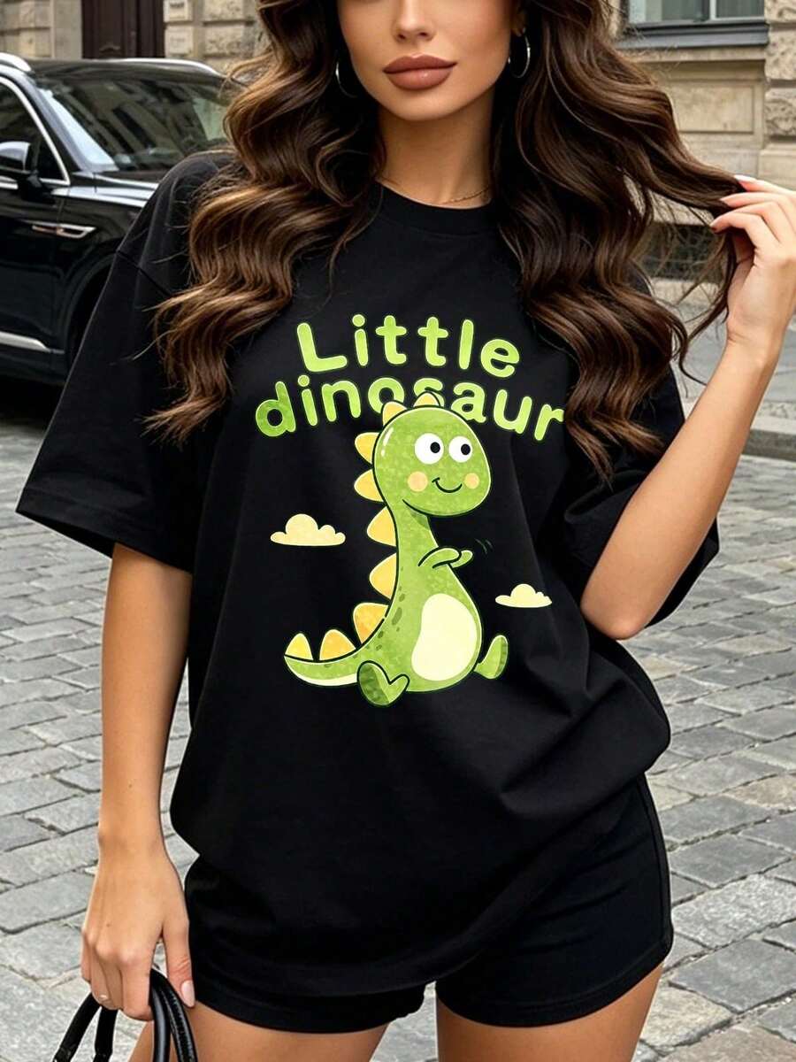 Camiseta de manga corta con cuello redondo suave y casual para mujer, con estampado gráfico de un pequeño dinosaurio, adecuada para conjuntos casuales de primavera y verano. Blanca. - Negro - Ver 1